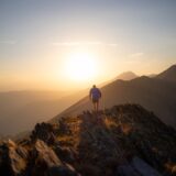 自己超克を象徴する、夕暮れの山の稜線を歩く人物