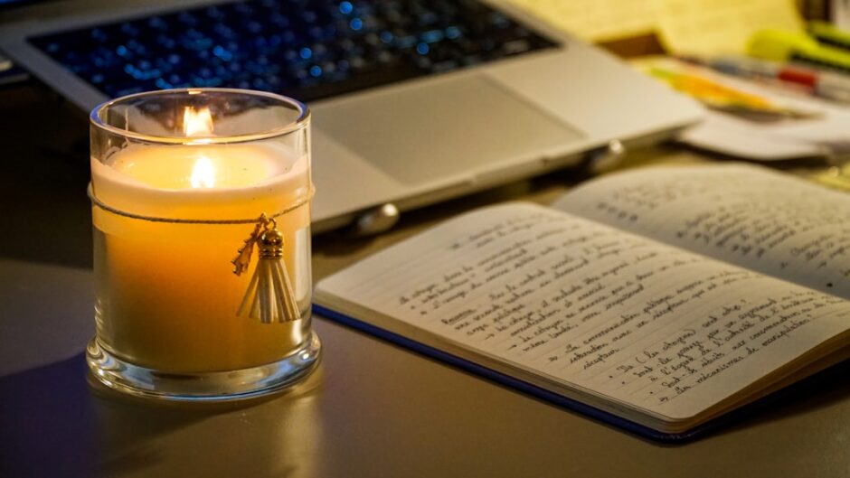 夜の振り返りをイメージした、灯りとノートのある机
