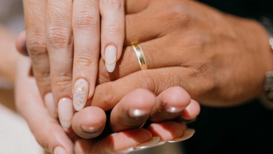 結婚指輪を着けた二人が手を重ねる様子