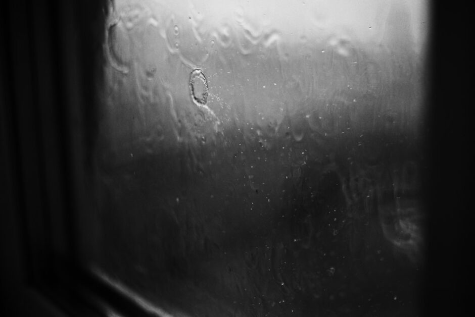 雨粒のついた窓ガラス。静かな時間を感じさせる横長の写真